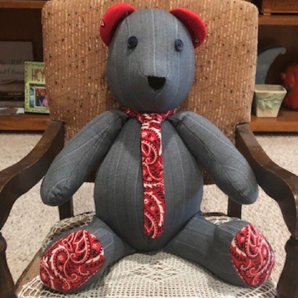 This gray flannel teddy bear has red bandana feet and ears and a bandana tie. He is custom made from a gray dress shirt.