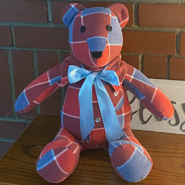 This red and blue plaid flannel bear with a blue ribbon is a way to hug something that reminds us of someone who has passed away.