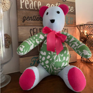 Colorful and cute Patchwork Memory Bear is hand sewn and sits on a mantle.